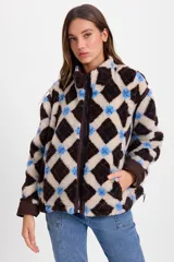 Campera de corderito sintético con diseño de rombos en tonos marrón, beige y azul. Presenta cuello alto, cierre frontal completo, bolsillos laterales y puños en color marrón sólido. Su diseño es holgado y cuenta con un cordón elástico ajustable en el ruedo.