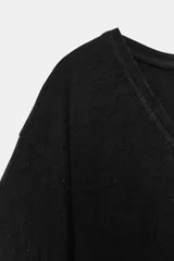 Camiseta negra de corte regular fit, con escote en V y mangas cortas amplias.