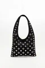 Cartera tipo hobo confeccionada en gamuza negra, con asa integrada y decorada en toda su superficie con tachas metálicas plateadas dispuestas en patrones geométricos.