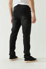 Jean negro de corte slim, con tiro medio, cinco bolsillos y cierre con cremallera y botón. Confeccionado en denim de algodón con spandex.