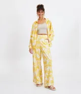 Pantalón pantalona de lino con estampado de cocoteros, cintura alta y cierre lateral invisible.