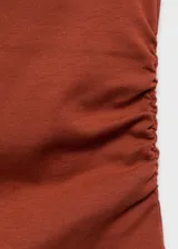 Camiseta sin mangas de cuello perkins, diseño entallado con fruncidos laterales y tirantes anchos.