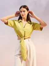 Camisa de textura arrugada en color verde lima, con cuello clásico, mangas cortas y diseño frontal anudado en la cintura.