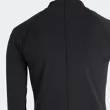 Campera deportiva New Balance de ajuste entallado, color negro, con cierre frontal completo, cuello alto y mangas largas. Presenta costuras reforzadas y el logo reflectante de la marca en el pecho.