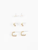 Set de tres pares de aros dorados: un par de aros tipo botón con piedra blanca, un par de aros tipo argolla gruesa y un par de aros tipo argolla cuadrada.