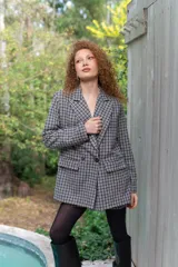 Blazer de paño con estampa a cuadros en tonos marrones y beige, de corte recto y mangas largas.