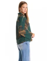 Camisa de crepe con estampado floral en tonos verdes y marrones, cuello con solapa, cierre frontal con botones y detalle de mostacillas bordadas en los hombros. Presenta mangas largas con terminación amplia.