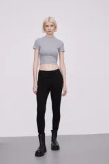 Pantalon skinny de tiro medio, confeccionado en tejido de algodón con elastano, con cierre frontal y bolsillos laterales.