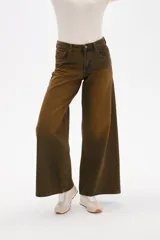 Pantalon de jean de corte ancho y tiro medio, con efecto de lavado desgastado en tonos marrones y verdosos. Cuenta con bolsillos laterales y traseros.