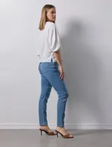 Blusa de gasa blanca con estampado de hojas en azul marino, cuello a la base con escote en V y botones, y mangas cortas abullonadas.