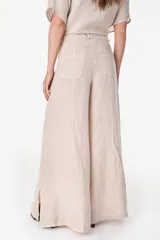 Pantalón de lino italiano con diseño estampado a rayas verticales en tonos negro y beige, de tiro medio y corte ancho.
