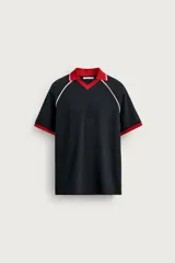 Polo de manga corta relaxed fit confeccionado en tejido de algodón con estructura abierta, color negro con detalles en rojo y líneas blancas en cuello y puños.
