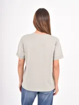 Remera de algodón blanca, de corte holgado y cuello redondo, con mangas cortas de diseño clásico.