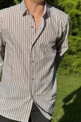 Camisa de lino color beige con rayas verticales blancas, de manga larga y corte clásico.