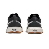 Championes Vans modelo UltraRange, color negro con detalles en blanco y gris. Presentan diseño de caña baja, con suela de goma color caramelo y entresuela blanca. Incluyen la icónica franja lateral de la marca y cordones grises.