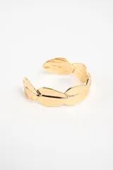 Brazalete rígido abierto de metal dorado con diseño de hojas unidas en todo su contorno.