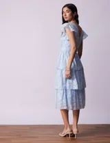 Vestido midi celeste de gasa estampada, marca Julia Jordan. Tiene escote en V, mangas cortas con volados y forro interno a tono.