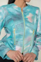 Campera de cuero sintético estampada con diseño abstracto en tonos celeste, rosa y gris. Cierre frontal y bolsillos laterales con cremalleras doradas.