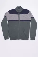Campera tejida de punto con cierre frontal completo y cuello alto. Presenta un diseño de bloques de color en tonos verde, gris y azul marino, con logo bordado en el pecho.