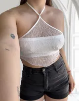 Top blanco de encaje con tirantes finos y espalda descubierta.