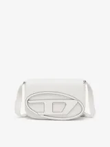 Bandolera mediana de cuero liso color blanco, modelo 1DR. Presenta una solapa frontal con una gran placa metálica esmaltada con el logo D ovalado. Incluye correa ajustable para llevar al hombro o cruzada y compartimento interior amplio con dos secciones planas adicionales.
