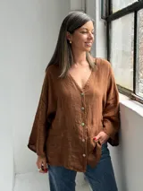 Camisa de lino color tabaco, con escote en V y cierre frontal con botones.