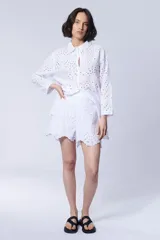 Short blanco con bordado calado tipo broderie, cintura elastizada y ruedo con volados.