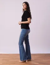 Buzo azul de tejido acanalado, con cuello solapa y escote en V en tejido calado.