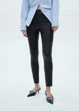 Pantalón de efecto piel en color negro, con corte slim fit y cintura elástica. Diseño largo y entallado sin cierre.