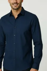 Camisa blanca de algodón, de diseño holgado y manga larga, con cuello camisero y cierre frontal de botones.