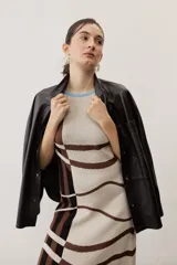 Camisa de cuero color negro, de manga larga con puños abotonados, cierre frontal con broches metálicos y un bolsillo aplicado en el pecho.