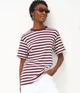 Remera oversized de manga corta y cuello redondo, confeccionada en algodón con diseño de rayas horizontales en color blanco y negro.