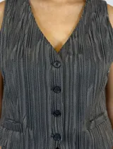 Chaleco de corte sastre en color gris con textura jaspeada, cierre frontal de botones y bolsillos laterales discretos.