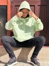 Canguro oversize de rústico de algodón con diseño a rayas horizontales en color verde menta y blanco. Presenta capucha, escote con broches frontales, bolsillo tipo canguro al frente y puños elásticos en mangas y ruedo.