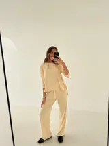 Conjunto de pantalón y blusa color crema, de morley y viscosa, con corte recto y bolsillos laterales.