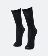 Par de medias negras de caña larga, confeccionadas en algodón con textura acanalada en relieve y textura de toalla en la planta del pie.