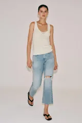 Jeans de tiro medio y corte bootcut cropped de Zara Woman Collection. Confeccionados en denim de efecto lavado en color celeste, presentan diseño de cinco bolsillos, trabillas para cinto, detalle de rotura en la rodilla izquierda y bajo evasé sin costuras. Cierre frontal con cremallera y botón metálico.