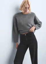 Jeans negros de tiro medio a bajo, corte recto y holgado, con diseño clásico de cinco bolsillos y cierre frontal con botón y cremallera.
