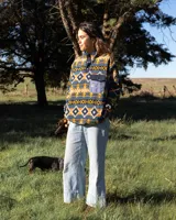 Buzo polar de cuello alto con cierre frontal de botones a presión, confeccionado en tejido fleece sintético con estampado geométrico multicolor. Presenta un bolsillo frontal con solapa y cierre de botón, además de bolsillos laterales ocultos.