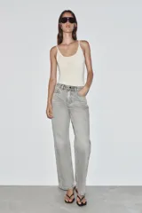 Jeans de tiro alto, pernera recta y larga, estilo clásico con cinco bolsillos, cierre frontal con cremallera y botón metálico.