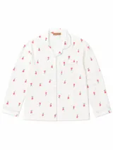 Camisa de pijama de manga larga con cuello solapa, cierre frontal de botones y bolsillo en el pecho. Presenta un estampado de pequeñas flores rojas sobre fondo blanco con detalles de ribetes en color lila.