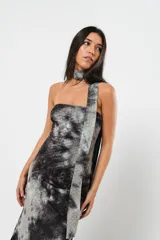Vestido largo strapless con estampado batik en tonos grises y negros. Incluye una tira de tela que se puede usar como cuello halter. Tiene tajo en ambos costados.