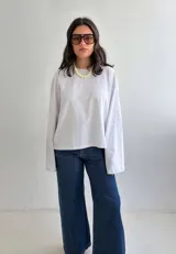 Remera oversize de color blanco, confeccionada en algodón suave y liviano, con mangas extra largas y anchas.