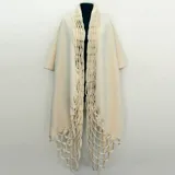 Capa azul de lana merino afieltrada, con guarda tejida en cuello y ruedo. Se puede usar como poncho o como capa abierta.