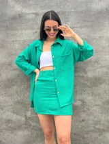 Camisa verde con botones dorados, de corte holgado y mangas largas.