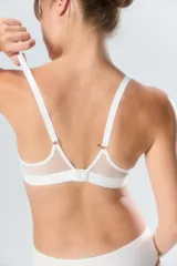 Soutien deportivo de algodón color beige, con diseño sin aro, breteles regulables y banda elástica inferior con logo de la marca.