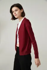 Cardigan color borgoña con escote en V y cierre con botones al frente. Tejido de punto fino.