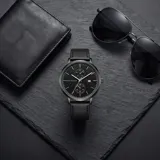 Reloj analógico Mini Focus con movimiento de cuarzo japonés, caja de aleación de zinc y correa de cuero negra. Presenta una esfera negra minimalista con subesferas y ventana de fecha.