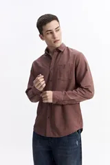 Camisa de manga larga color azul marino con textura, cuenta con cuello clásico, cierre frontal con botones y un bolsillo en el pecho.