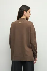 Polera color beige de manga larga con puños elastizados y aberturas laterales.